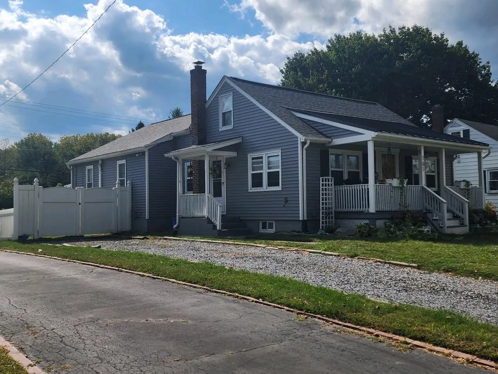 Asphalt shingle roof on a residential home with gray siding and white gutters.